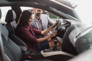 Jeune fille en train d'essayer une voiture bien équipée