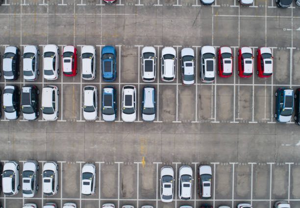 Parking avec plusieurs voitures d'occasion vues du ciel