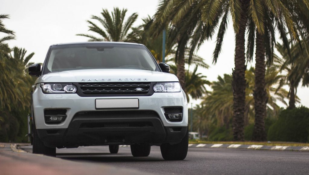 4x4 Range Rover sur une route bordée de palmiers